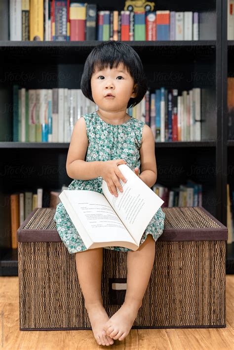 Adorable Girl Reading Books At Home By Stocksy Contributor Maahoo