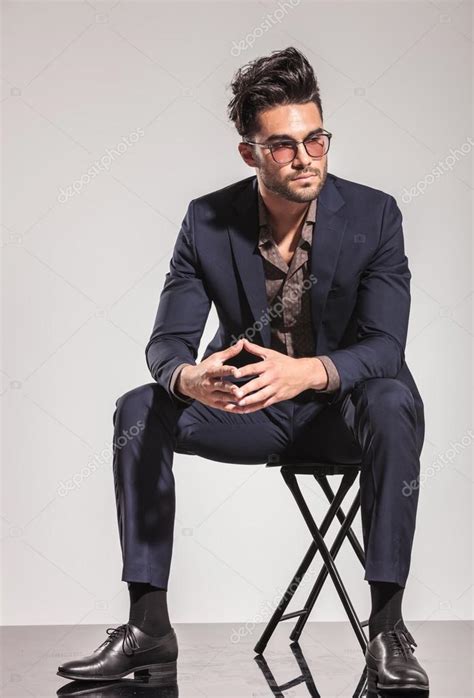 Fashion Man In Suit Sitting And Looks To Side Stock Photo By ©feedough