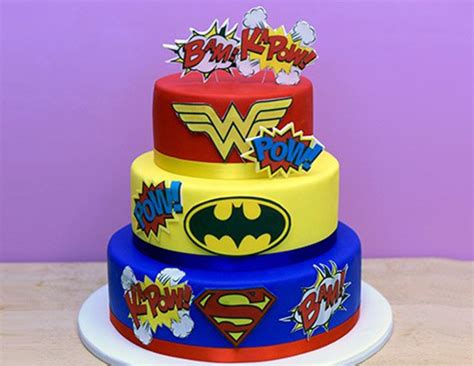Three Tiered Cake Decorated With Superman And Wonder Symbols