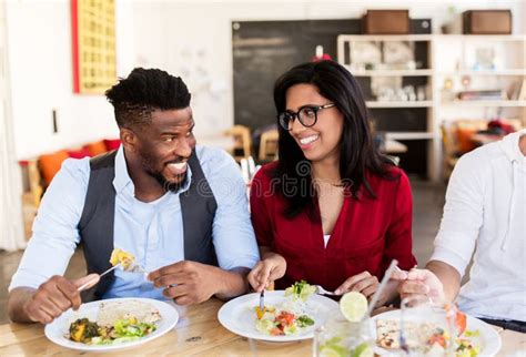 Happy Friends Eating And Talking At Restaurant Stock Photo Image Of