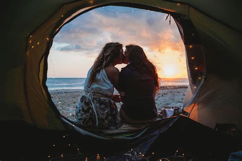 Lesbian Couple Kissing In Tent At Beach During Sunset Fashionista