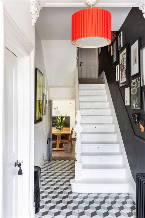 A Staircase Leading Up To A Living Room With Pictures On The Wall And