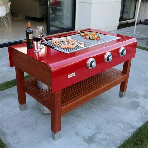 Rockwell By Caliber 60 Inch Propane Gas Grill On Wood Table Red Bbqguys