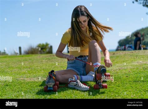 Pretty Teenage Girl In Yellow Top Sits On Grass Putting Retro Style