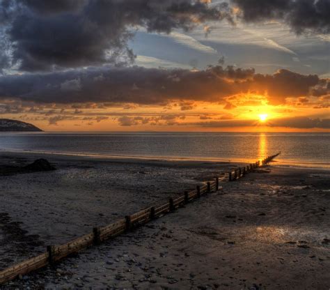 The sun sets on the beach at Douglas in the Isle of Man. | Sunset, Sunrise sunset, Sunrise