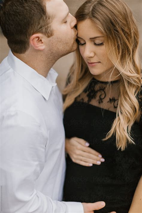 Husband Kissing His Pregnant Wife On The Forehead By Kristen Curette