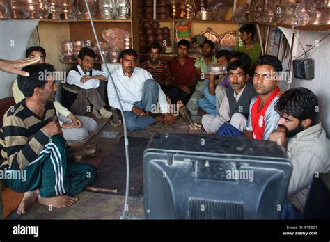 Men Watch An India Pakistan Cricket Match On A Tv In A Small Shop In