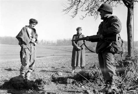 Two German Pows Are Guarded By A Us Army Soldier Of The