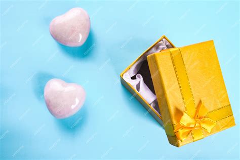 Premium Photo Two Pink Hearts And Yellow T Box On A Blue