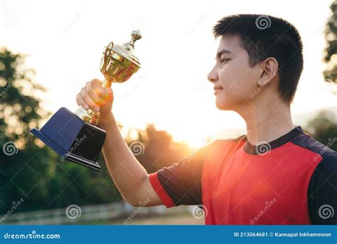 Asian Teenager Football Player Holding Trophy With Celebrate Pose Stock