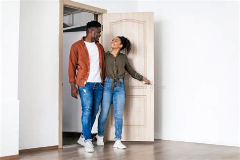 Happy Black Husband And Wife Hugging Entering Own House Stock Photo
