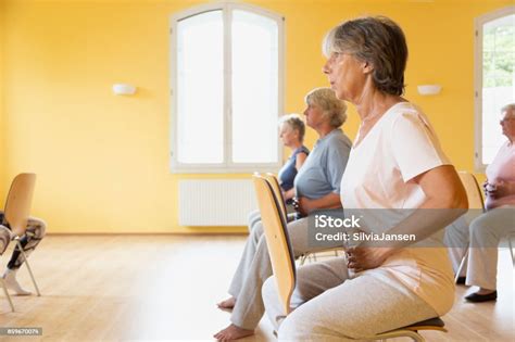 Active Senior Women Yoga Class On Chairs Doing Breathing Exercise Stock