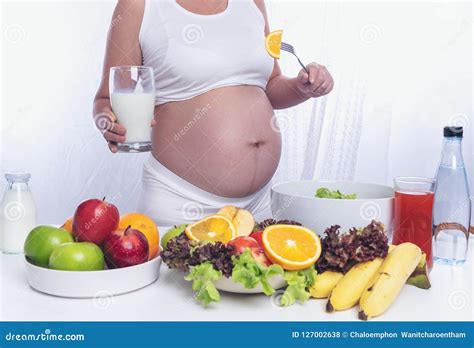 Pregnant Woman Is Cooking Fruit And Vegetable Salad Milk To Take Care