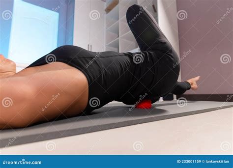 Close Up Young Caucasian Woman Doing Myofascial Self Massage Of Her Thigh And Buttocks With A