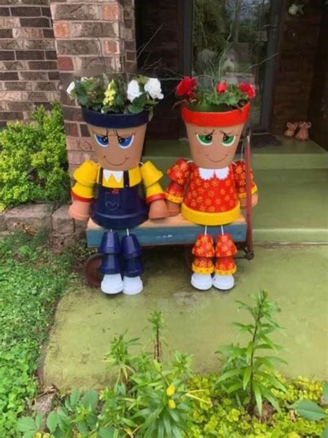 Two Garden Decorations Sitting On Top Of A Wooden Bench
