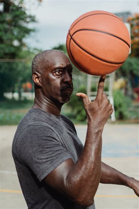 Man Holding Ball On Finger · Free Stock Photo