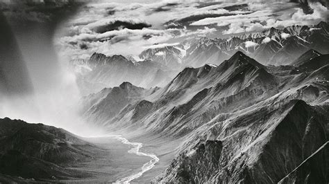 Black And White Photograph Of Mountains With Clouds In The Sky Taken