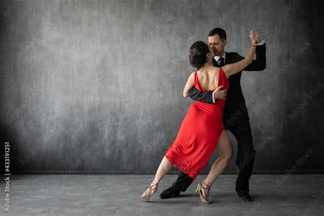couple of professional tango dancers in elegant suit and dress pose in a dancing movement on