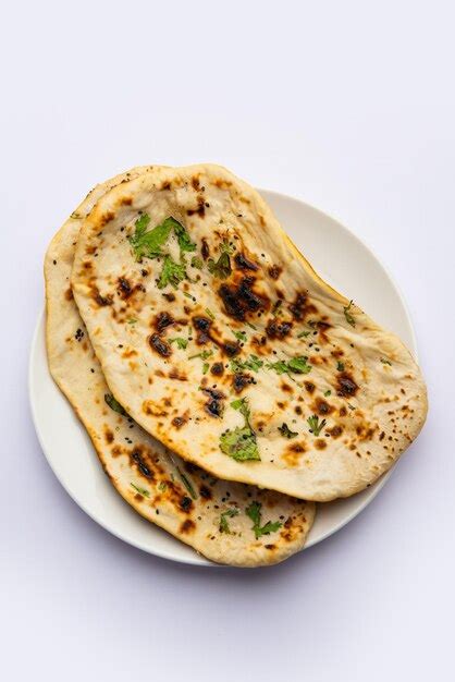 탄두리 난 인도 탄두리 로티 또는 납작한 빵이 분리된 접시에 담겨 제공됩니다 무료 사진
