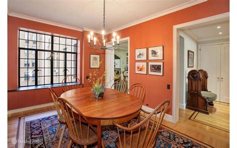 The Orange Wall And Candle Light Chandelier Makes The Dining Room A