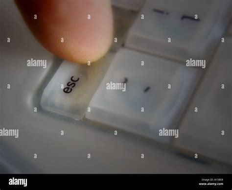 Finger Pressing Esc Key On Computer Keyboard David Hughes Stock Photo