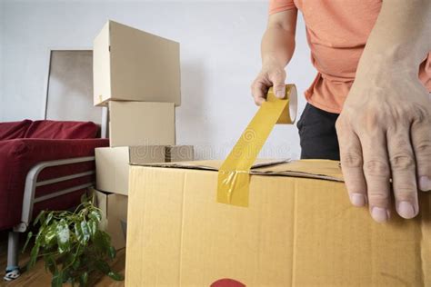 Closeup Of Man Packing Cardboard Box Moving To A New House Stock Image