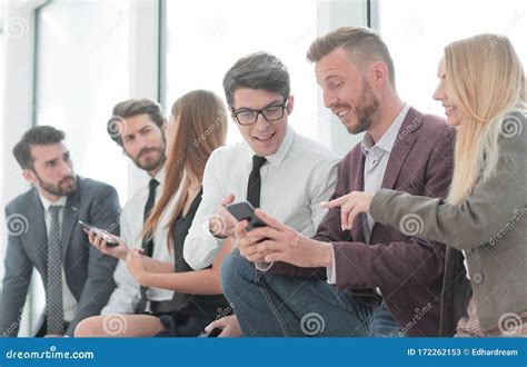 Young Employees Using Their Smartphones To View The News Online Stock Image Image Of Managers