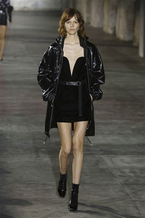 A Model Walks Down The Runway In A Short Black Dress