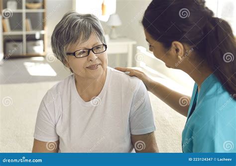 Portrait Of Female Nurse Caregiver Putting Hand On Senior Woman Patient