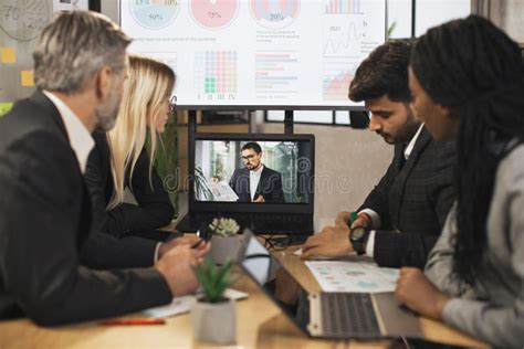 Group Of Businesspeople Having Video Conference In Boardroom In Modern