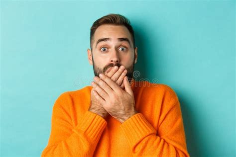 Close Up Of Shocked Caucasian Man Covering His Lips And Mouth Staring