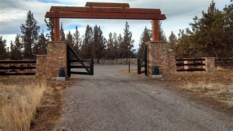 An Open Gate Leading To A Dirt Road