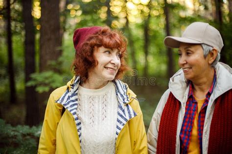 Two Senior Female Friends Hiking Together Through The Forest In Autumn
