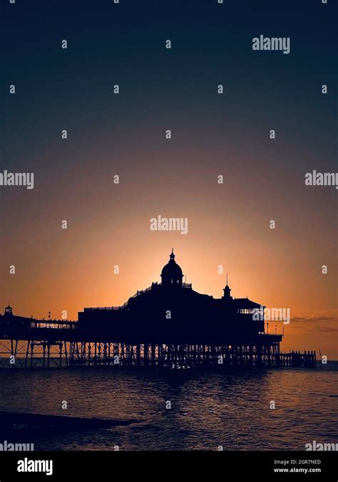 Silhouette Of Eastbourne Pier At Sunrise With Clear Skies Stock Photo