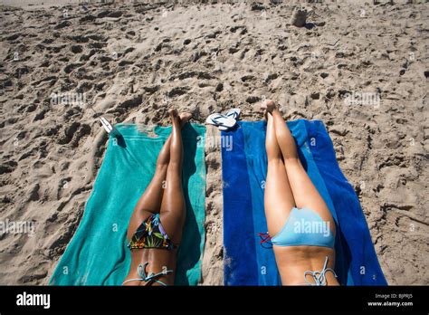 Legs Of Two Women Sunbathing At The Beach Stock Photo Alamy