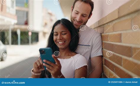 Man And Woman Interracial Couple Hugging Each Other Using Smartphone At Street Stock Footage