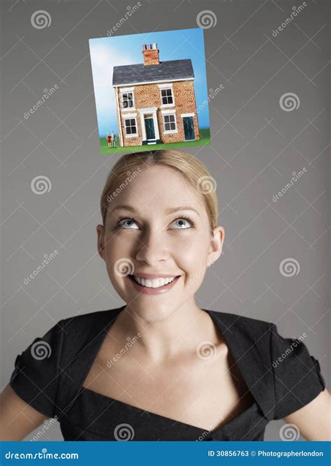 Model Home On Top Of Young Woman S Head Representing Homeownership