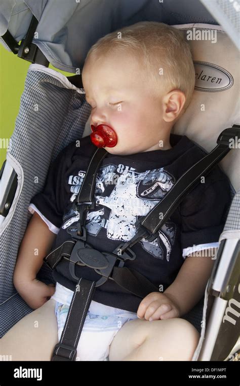 1 Year Old Boy Asleep In The Pram With A Dummy In His Mouth Stock Photo