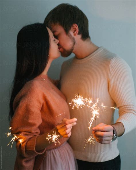 Kissing Couple Holding Sparklers By Stocksy Contributor Duet Postscriptum Stocksy