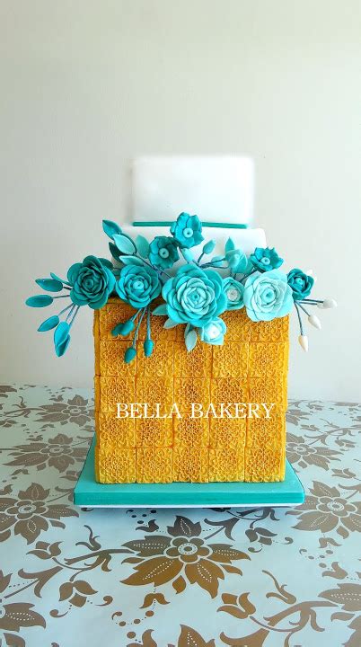 Teal And Gold Wedding Cake With Ranunculus Flowers