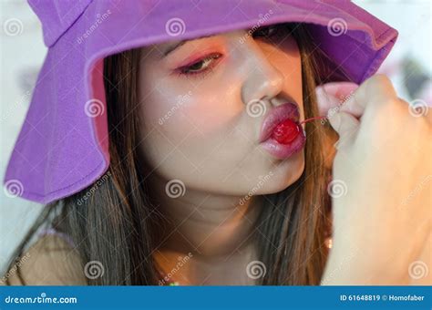 Closeup Of Pretty Lady With Makeup Sucking A Sweet Cherry Stock Image