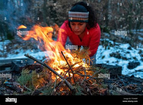 Woman Starting A Bonfire At A Fireplace In The Forest In Autumn Stock