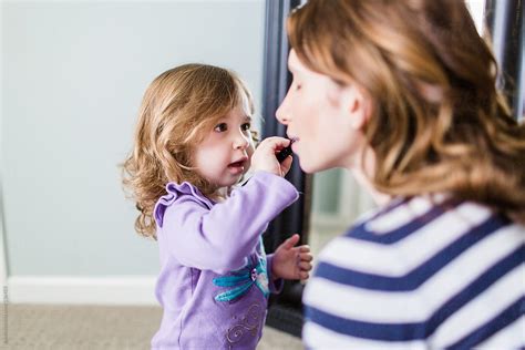 Mother And Baby Daughter Playing With Make Up In The Bedroom By Stocksy Contributor Jakob