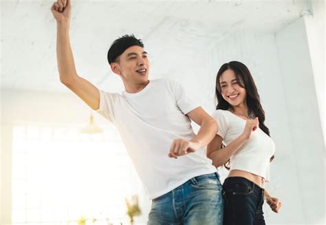 Premium Photo Happy Young Couple Dancing In Living Room At Home