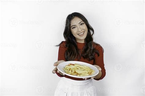 imagen de sonriente joven asiático niña comiendo francés papas fritas aislado en blanco