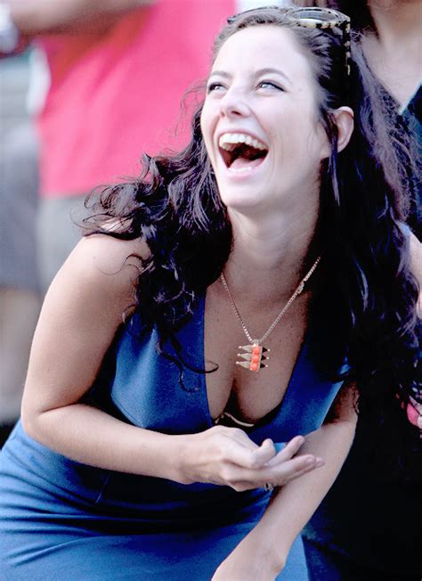 A Woman Laughing While Sitting On The Ground