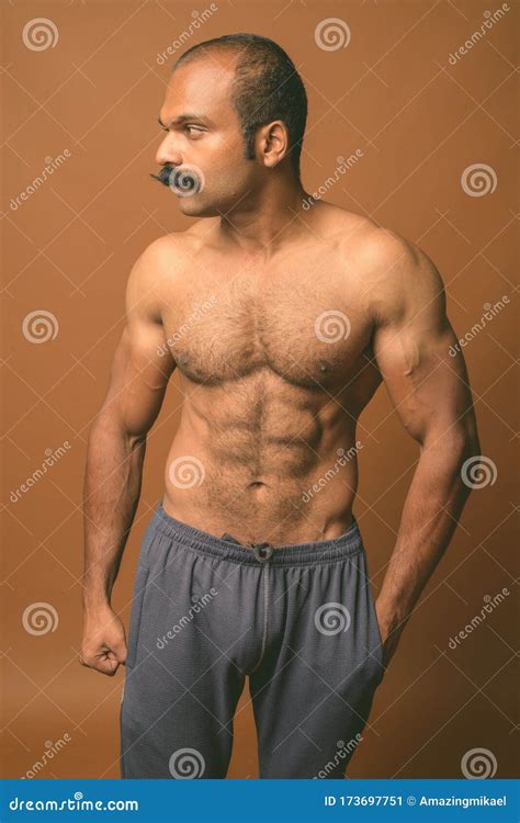 Muscular Indian Man With Mustache Shirtless Against Brown Background Stock Image Image Of