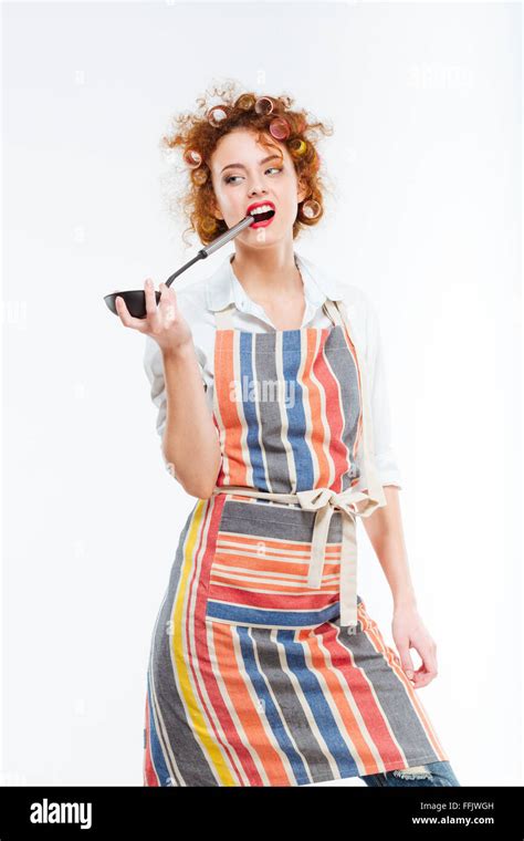 Attractive Redhead Young Housewife With Curlers In Kitchen Apron