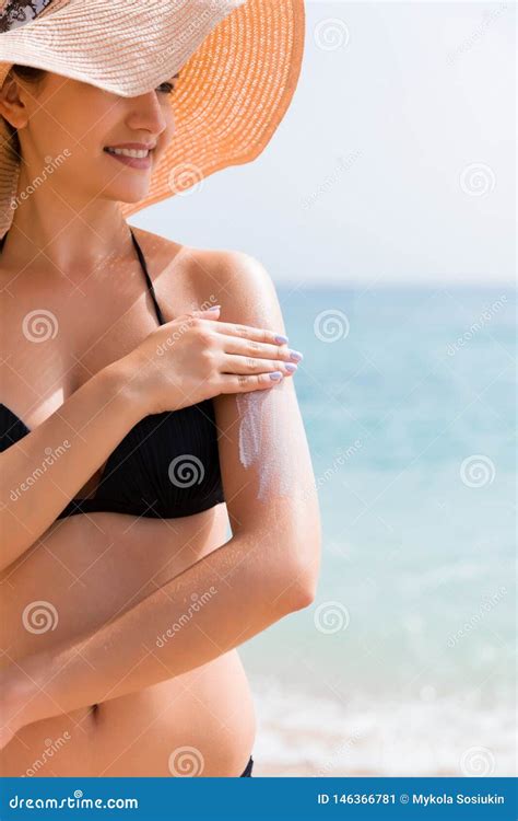 Sunscreen Sunblock Woman In A Hat Putting Solar Cream On Shoulder Outdoors Under Sunshine On