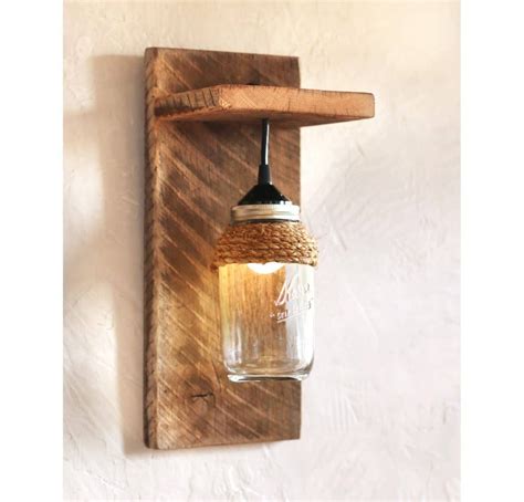 A Mason Jar Hanging From A Wooden Wall Light